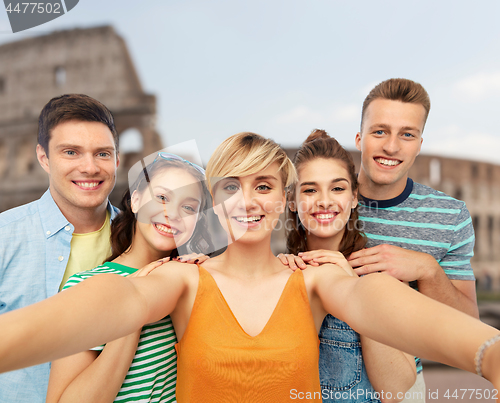 Image of happy friends taking selfie over coliseum