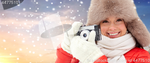 Image of happy woman with film camera outdoors in winter