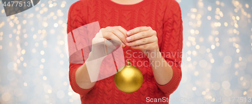 Image of close up of woman in sweater with christmas ball