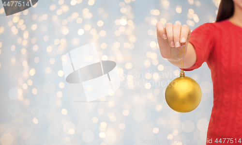 Image of close up of woman in sweater with christmas ball