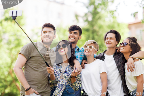 Image of friends taking picture by selfie stick at summer