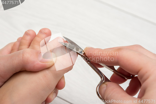 Image of Mom mows the toenails of the child, close-up