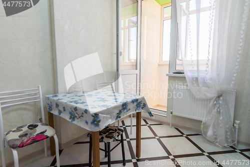 Image of A small kitchen table stands near the balcony