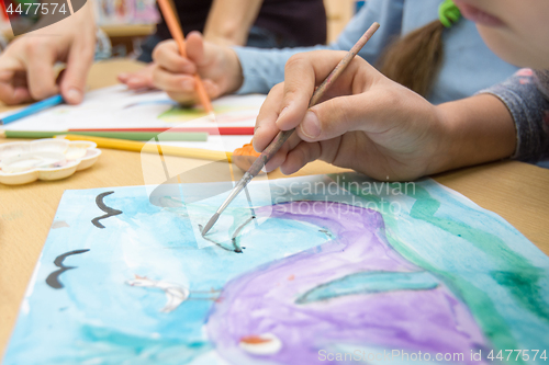 Image of Hand draws a drawing in a school of drawing