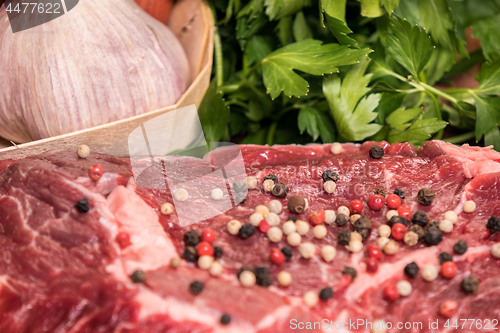 Image of steak of beef on a wooden board with spices pepper parsley salt 