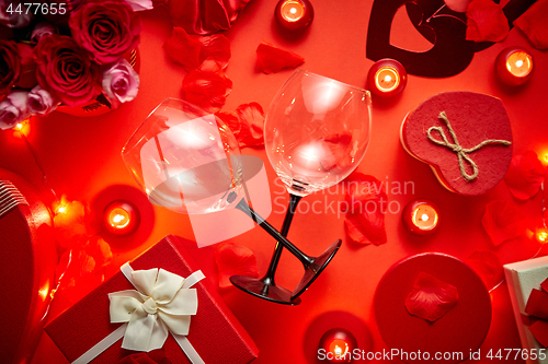 Image of Valentines day romantic decoration with roses, wine glasses, boxed gifts, candles