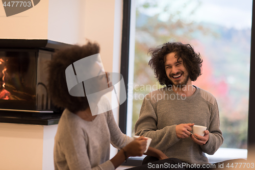 Image of multiethnic couple  in front of fireplace