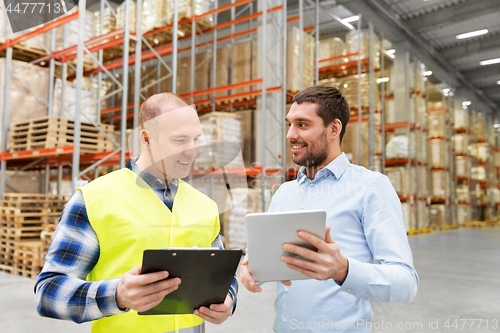 Image of worker and businessman with tablet pc at warehouse