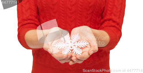 Image of close up of woman in red sweater holding snowflake