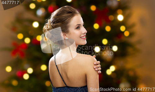 Image of beautiful woman over christmas tree lights