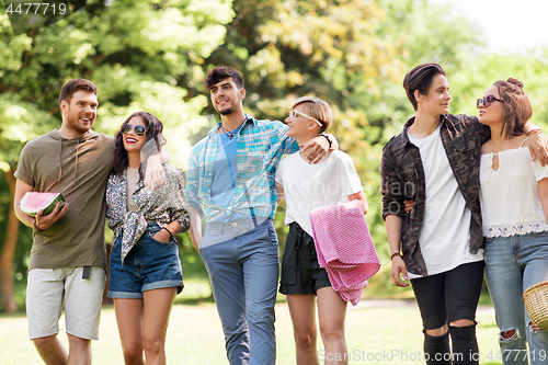 Image of happy friends with picnic blanket at summer park