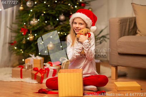 Image of smiling girl in santa hat with christmas gift