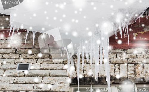 Image of icicles and snow hanging from building roof