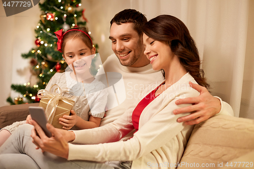 Image of family with smartphone at home on christmas