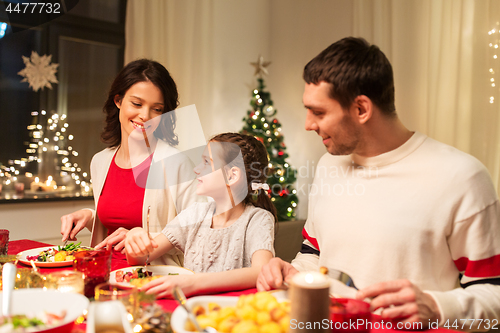 Image of happy family having christmas dinner at home