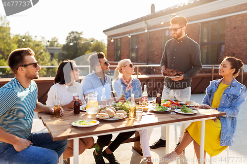 Image of friends at barbecue party on rooftop in summer