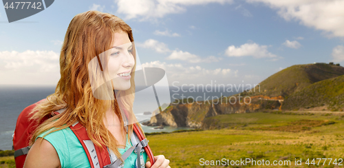 Image of smiling woman with backpack on big sur coast