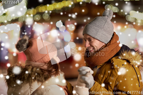 Image of happy couple holding hands at christmas market