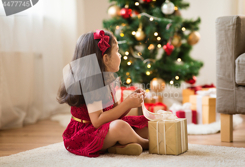 Image of little girl with christmas gift at home