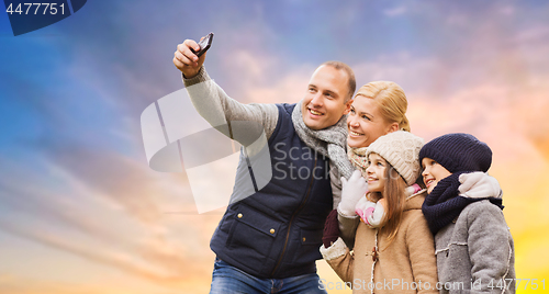 Image of family taking selfie by smartphone over sky