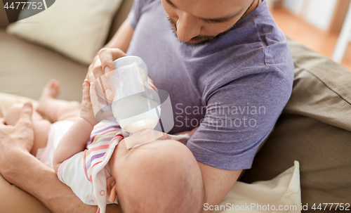 Image of close up of father feeding baby from bottle