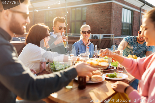 Image of friends having dinner or bbq party on rooftop