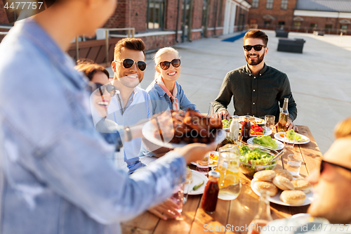 Image of friends at barbecue party on rooftop in summer