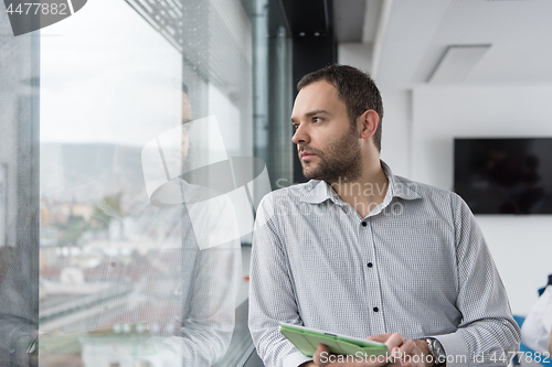 Image of Businessman Using Tablet In Office Building by window