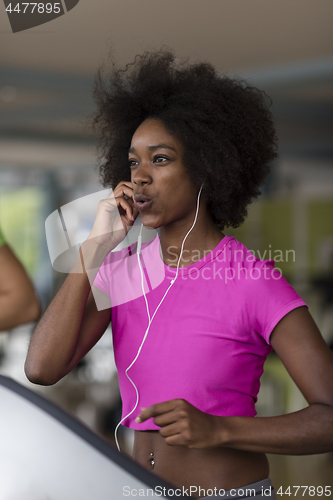 Image of afro american woman running on a treadmill