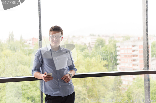 Image of Businessman Standing In A Modern Building Near The Window With P