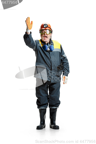 Image of The studio shot of senior bearded male miner standing at the camera on a white background.