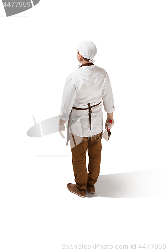 Image of The back of serious butcher posing with a cleaver isolated on white background