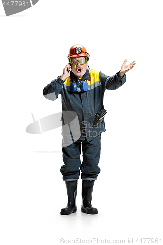 Image of The studio shot of surprised senior bearded male miner standing at the camera with smartphone on a white background.