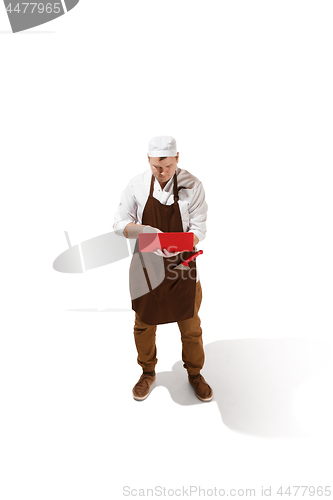 Image of Serious butcher posing with a laptop isolated on white background