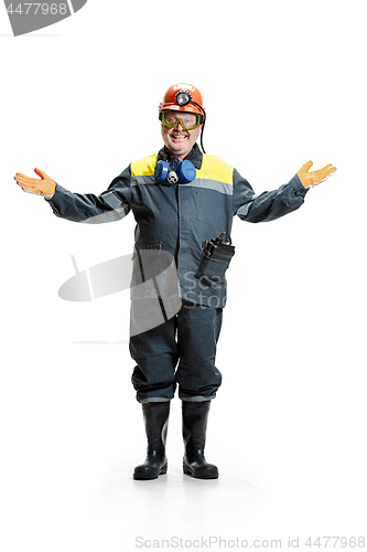 Image of The studio shot of happy senior bearded male miner standing at the camera on a white background.