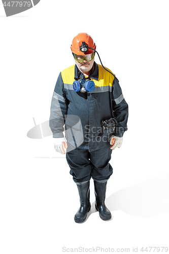 Image of The studio shot of senior bearded male miner standing at the camera on a white background.