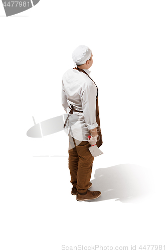 Image of The back of serious butcher posing with a cleaver isolated on white background