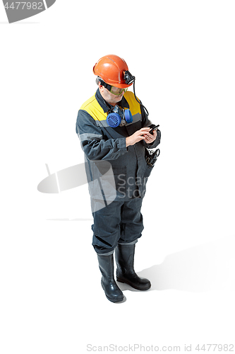 Image of The studio shot of senior bearded male miner standing at the camera on a white background.