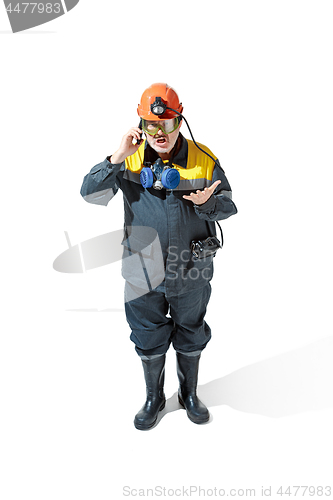 Image of The studio shot of senior bearded male miner standing at the camera on a white background.