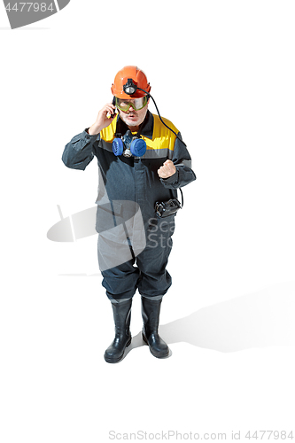 Image of The studio shot of senior bearded male miner standing at the camera on a white background.