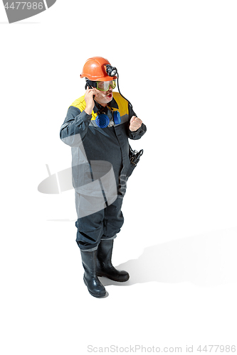 Image of The studio shot of senior bearded male miner standing at the camera on a white background.