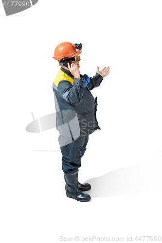 Image of The studio shot of senior bearded male miner standing at the camera on a white background.