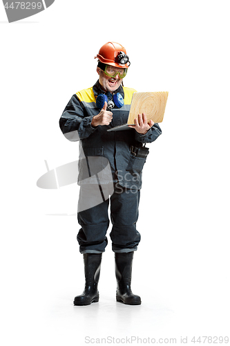 Image of The studio shot of happy senior bearded male miner standing at the camera with laptop on a white background.