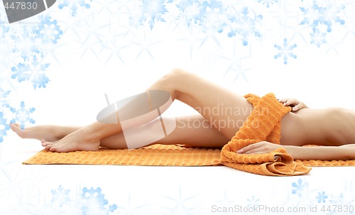 Image of long legs of relaxed lady with orange towel