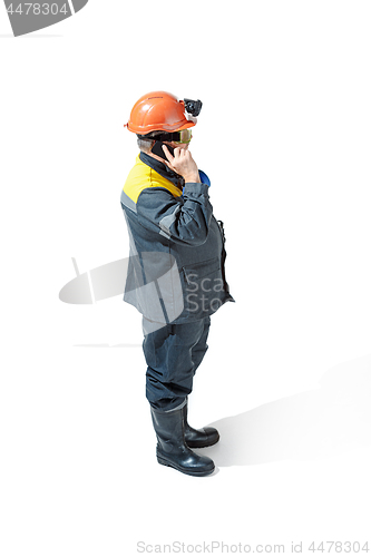 Image of The studio shot of senior bearded male miner standing at the camera on a white background.