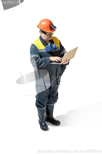 Image of The studio shot of senior bearded male miner standing at the camera on a white background.