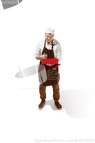 Image of Serious butcher posing with a laptop isolated on white background