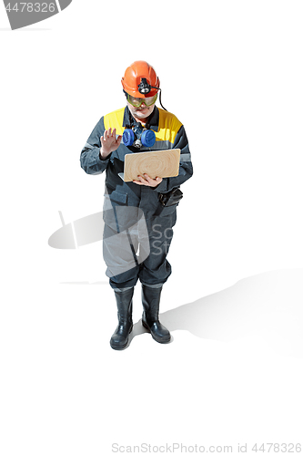 Image of The studio shot of senior bearded male miner standing at the camera on a white background.