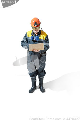 Image of The studio shot of senior bearded male miner standing at the camera on a white background.