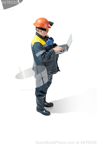 Image of The studio shot of senior bearded male miner standing at the camera on a white background.